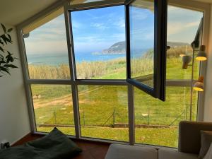 Habitación con ventana grande con vistas al océano. en Apartamento Suite mirando al mar, en Porto de Espasante