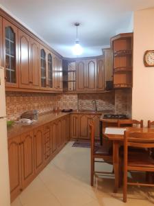 a large kitchen with wooden cabinets and a table at Emily House in Fier