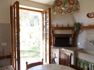 eine Küche mit einem Tisch und einem Glasfenster in der Unterkunft Ferienwohnung für 4 Personen ca 100 m in Marciaga, Gardasee Ostufer Gardasee in Marciaga