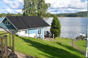 ein Haus am Ufer eines Sees in der Unterkunft Sjöstuga/gästhus i skärgården. in Åkersberga