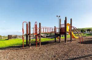 a playground with a slide in a park at Sea La Vie Lodge in New Quay