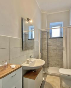 bagno bianco con lavandino e servizi igienici di Amoenus Bed & Breakfast a Soverato Marina