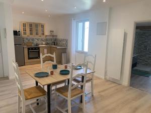 cocina y comedor con mesa de madera y sillas en Le Jalet en Provence - Penthouse, en Sisteron