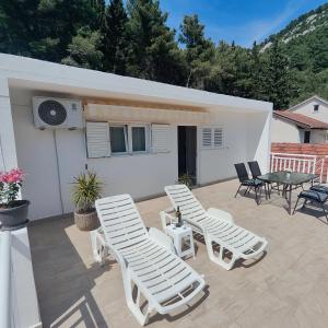 a patio with lounge chairs and a table and a house at Apartment Matic Duboka in Duboka