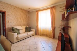 uma sala de estar com um sofá e uma janela em holiday flat with high speed internet em Tocco da Casauria