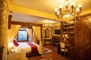 a bedroom with a bed and a chandelier at Rajkamal-The Himalayan Heritage in Shimla