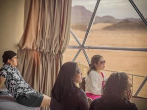 a group of women sitting in front of a window at RUM NEPTUNE lUXURY CAMP in Wadi Rum