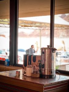 RUM NEPTUNE lUXURY CAMP في وادي رم: وجود آلة صنع القهوة على رأس طاولة