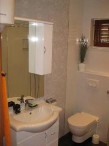 uma casa de banho com um lavatório branco e um WC. em Ferienwohnung für 4 Personen ca 45 qm in Srima, Dalmatien Norddalmatien - b60464 em Srima