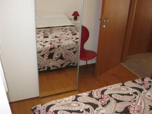 um quarto com um espelho, uma cama e uma cadeira vermelha em Ferienwohnung für 4 Personen ca 45 qm in Srima, Dalmatien Norddalmatien - b60464 em Srima
