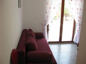 um sofá vermelho numa sala de estar com uma janela em Ferienwohnung für 4 Personen ca 45 qm in Srima, Dalmatien Norddalmatien - b60464 em Srima