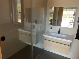 ein Bad mit einem Waschbecken und einem Spiegel in der Unterkunft Casa moderna in El Carrer de Dalt