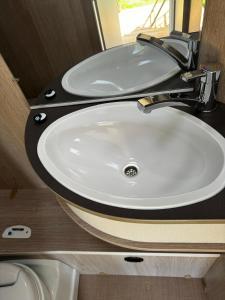 a bathroom with a white sink and a mirror at Reisemobil Zentrum Berlin in Berlin