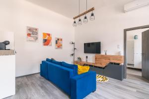 uma sala de estar com um sofá azul e uma televisão em Heroes' Square Stay em Budapeste