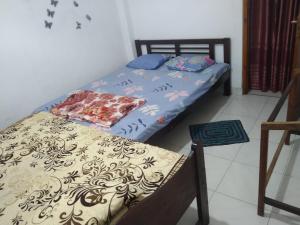 een slaapkamer met 2 aparte bedden en een stoel bij Green Haven Guest Inn in Badulla
