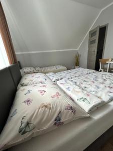 Una cama con un edredón con mariposas. en Pensjonat Zatoka 17, en Władysławowo