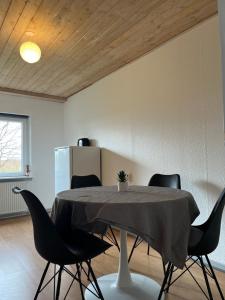 a dining room with a table and black chairs at Cozy Apartment in Billund in Billund