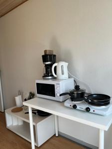 a microwave with a coffee maker on top of it at Cozy Apartment in Billund in Billund