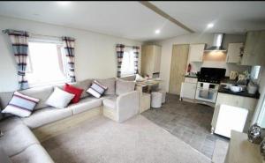 sala de estar con sofá y cocina en The Beautiful 3 bedroom static caravan, on Haven Golden sands Mablethorpe, en Mablethorpe