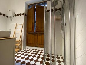 a bathroom with a shower and a checkered floor at La sosta del viandante in Sinalunga