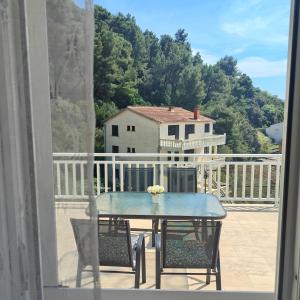 a table and chairs on a balcony with a house at Apartment Matic Duboka in Duboka