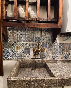 a sink in a kitchen with blue and white tiles at La sosta del viandante in Sinalunga