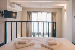 ein Schlafzimmer mit einem Bett mit zwei Handtüchern darauf in der Unterkunft LVM Stays in Den Haag