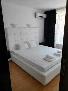 a white bed in a room with a window at Vila Antorini-Anikoapartman 2 in Sveti Vlas