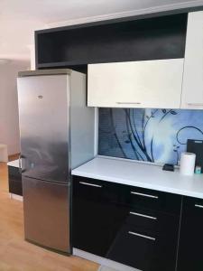 a kitchen with a refrigerator and a white counter top at Vila Antorini-Anikoapartman 2 in Sveti Vlas