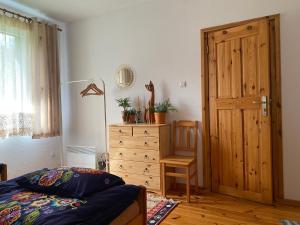 sypialnia z łóżkiem, komodą i drewnianymi drzwiami w obiekcie Apartament Hajstra z ogrodem w mieście Grodzisk