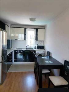 a kitchen with a table and a kitchen with a stove at Vila Antorini-Anikoapartman 2 in Sveti Vlas