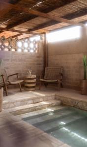 a patio with a pool and two chairs and a table at Moa Living in Ẕofar