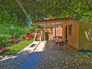 une terrasse d'une maison avec une table et des chaises dans l'établissement Ferienwohnung für 5 Personen ca 50 qm in Fažana, Istrien Istrische Riviera - b54513, à Fažana