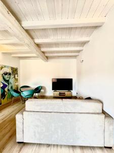 a living room with a white couch and a tv at CASA SUL LAGO in Arona