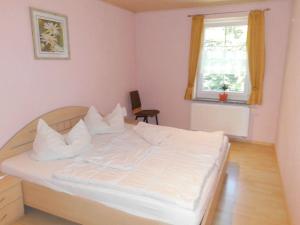 1 dormitorio con 1 cama con sábanas blancas y ventana en Ferienwohnung für 4 Personen ca 55 qm in Sayda, Sachsen Osterzgebirge, en Sayda