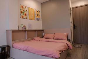 a bedroom with a bed with pink sheets on it at Halidao Homestay in Hai Phong