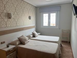 pokój hotelowy z 2 łóżkami i oknem w obiekcie PENSION NAVAS w mieście El Cabo de Gata