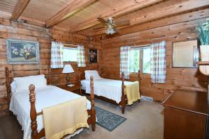 1 Schlafzimmer mit 2 Betten in einem Blockhaus in der Unterkunft Lazy Bear Retreat - Classic Cabin! in Morton Grove