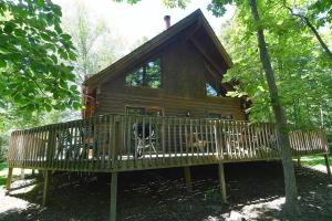 una cabaña de madera con un banco delante en Lazy Bear Retreat - Classic Cabin!, en Morton Grove