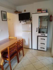 a kitchen with a table and a white refrigerator at Apartmani Vitković II Cres in Cres