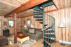uma sala de estar com uma escada em espiral num chalé em Mishka (Bear Cub Retreat)at Sleepy Creek em Berkeley Springs