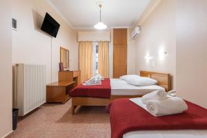 a hotel room with two beds and a television at Faros II in Piraeus
