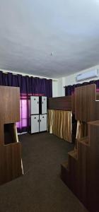 een lege kamer met tafels en stoelen en paarse gordijnen bij Pizza Street Hostel in Aqaba