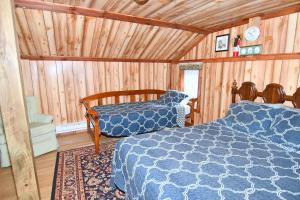 um quarto com 2 camas num quarto com paredes de madeira em Mishka (Bear Cub Retreat)at Sleepy Creek em Berkeley Springs