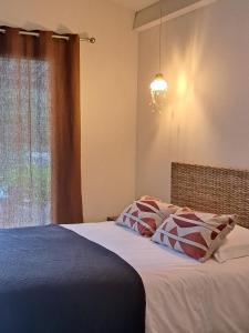 a bedroom with a bed with a chandelier and a window at songes d été 6 in Bonifacio