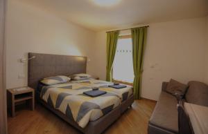 um quarto com uma cama, um sofá e uma janela em Casa Fiocco Di Neve em Livigno