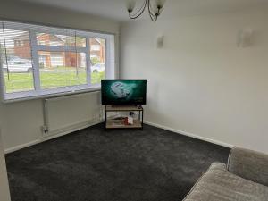 ein Wohnzimmer mit einem TV und einem Sofa in der Unterkunft Charming 3-Bed House in Leighton Buzzard in Leighton Buzzard