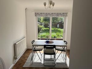 een eetkamer met een tafel en stoelen en een raam bij Charming 3-Bed House in Leighton Buzzard in Leighton Buzzard