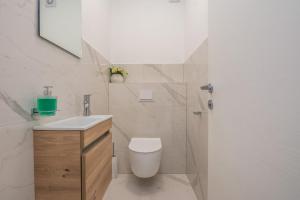 een witte badkamer met een toilet en een wastafel bij Ferienwohnung für 4 Personen ca 75 qm in Vir, Dalmatien Inseln vor Zadar - b53410 in Vir