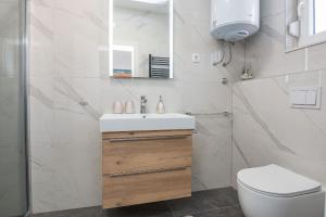 een witte badkamer met een wastafel en een toilet bij Ferienwohnung für 4 Personen ca 75 qm in Vir, Dalmatien Inseln vor Zadar - b53410 in Vir